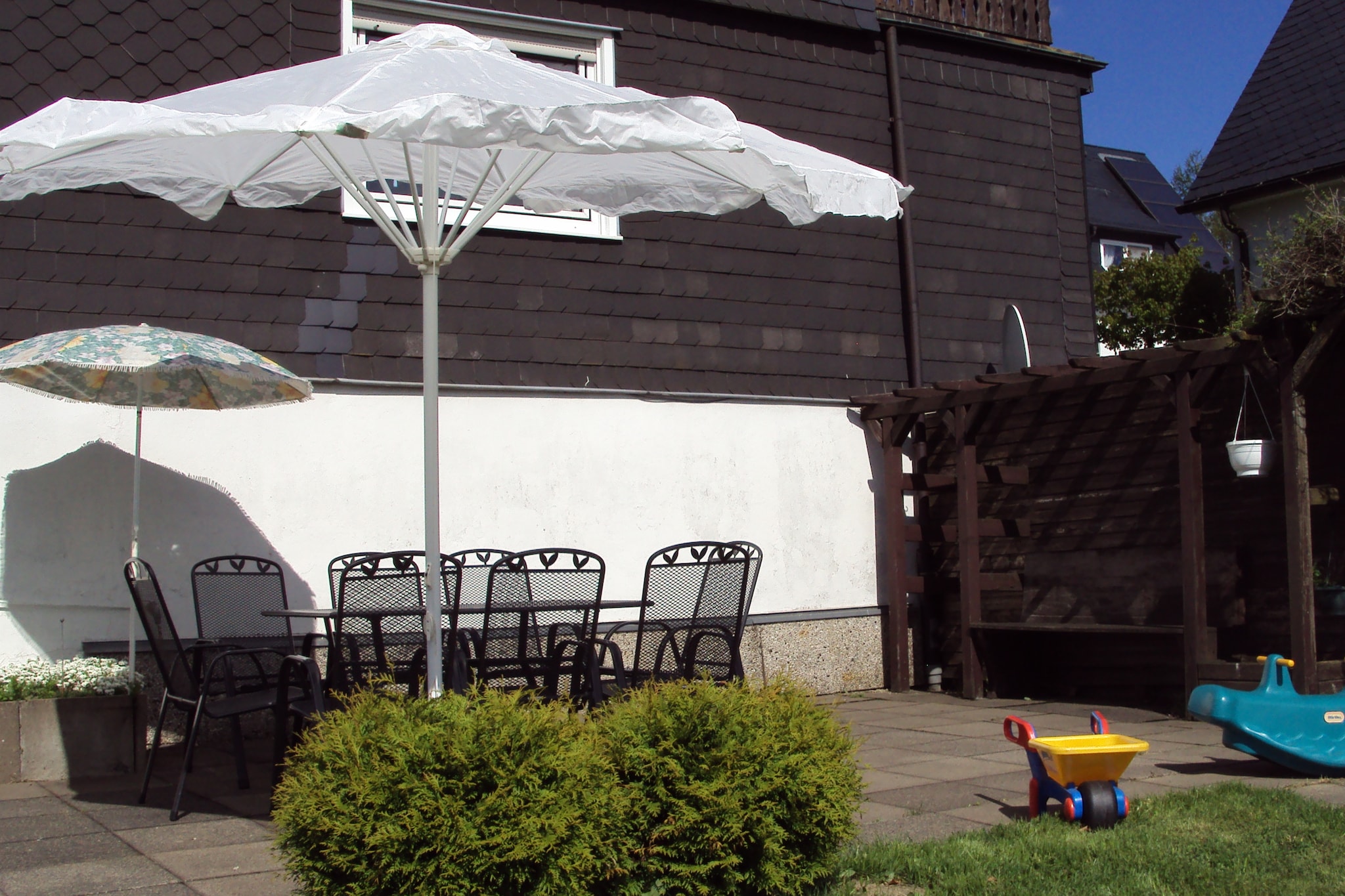 Ground floor: (Entrance, hall, Living room(DVD player, stereo unit), dining room(dining table(10 persons)), Kitchen(dining table(4 persons), electric kettle, toaster, cooker(ceramic), coffee machine(filter, pads), oven, microwave, dishwasher, fridge(+ freezer), freezer), toilet(washbasin))\n\nOn the 1st floor: (bedroom(double bed(200 x 200 cm)), bedroom(single bed(80 x 200 cm), double bed), bedroom(single bed(80 x 200 cm), double bed(160 x 200 cm)), bedroom(single bed(90 x 190 cm), single sofa bed, bunk bed), bathroom(bath tub, shower, washbasin, toilet), bathroom(shower, washbasin, toilet))\n\ncot, heating, terrace(private, 50 m2), garden(private, 600 m2), bicycle storage, garden furniture, parking, parasol, high chair