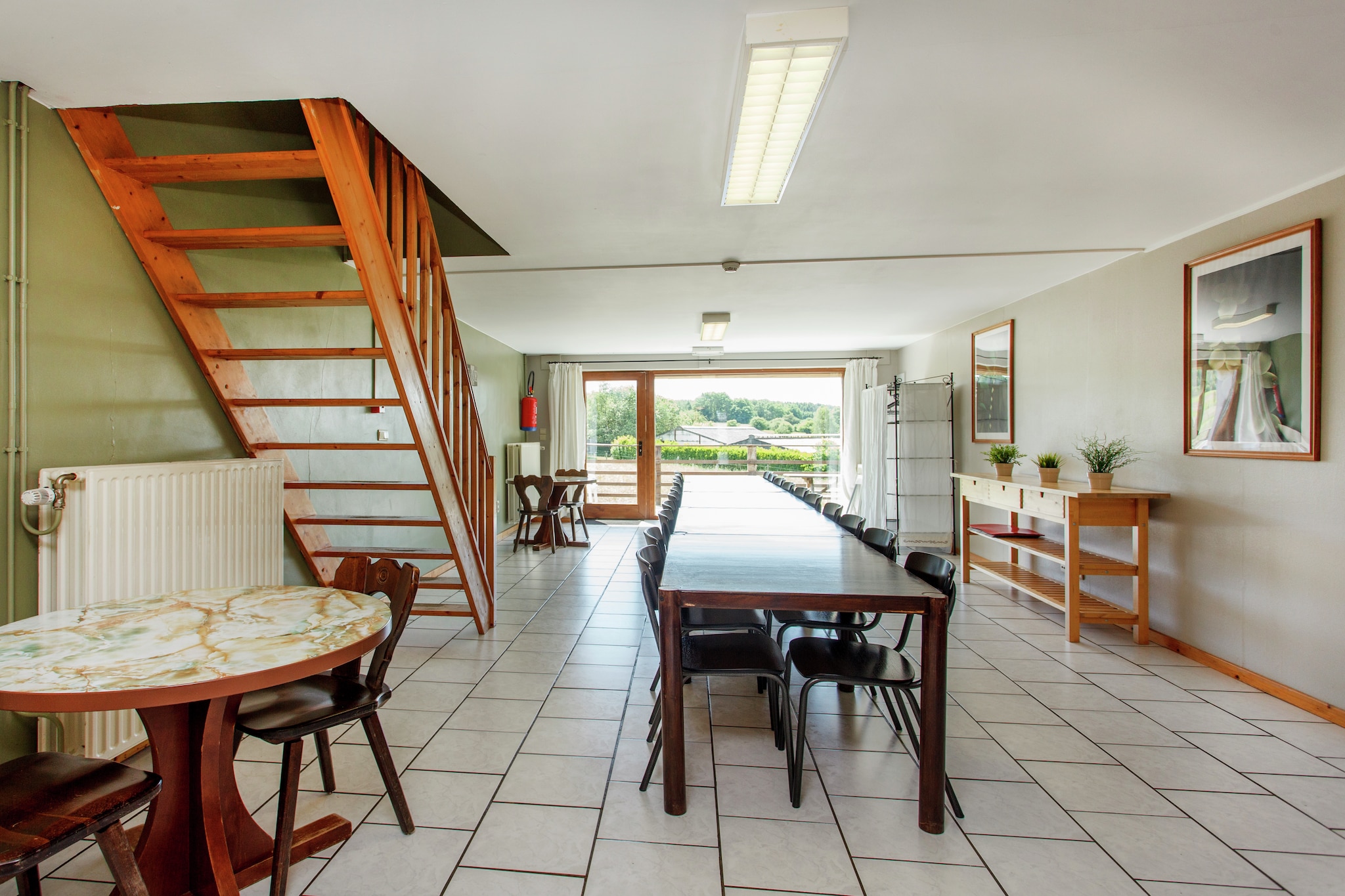 Ground floor: (hallway(acces via outside stairway))\n\nOn the 1st floor: (Sitting room(TV(cable)), dining room, Kitchen(oven, combination microwave, microwave, dishwasher), coffee machine)\n\nOn the 2nd floor: (bedroom(single bed, double bed), bedroom(single bed, bunk bed), bedroom(single bed, double bed), bedroom(double bed, bunk bed), bedroom(3x single bed), bedroom(3x single bed), bedroom(2x single bed), bathroom(shower, washbasin), bathroom(bath tub, washbasin), bathroom(bath tub, washbasin), toilet, toilet, toilet)\n\nterrace, garden(private), garden furniture, BBQ, play equipment