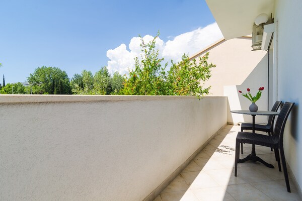 Sfeervolle studio met balkon en tuinzicht op loopafstand van strand - thumbnail 6