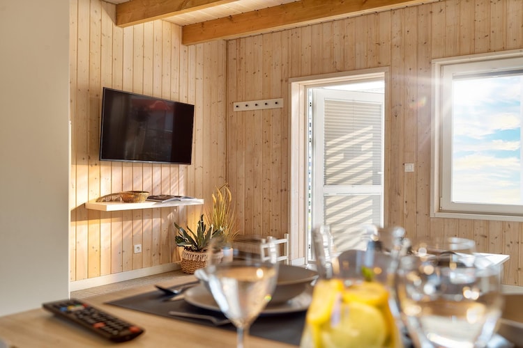 Ground floor: (open kitchen(hob(2 ring stoves, induction), electric kettle, toaster, microwave, dishwasher, fridge-freezer), Living/diningroom(double sofa bed, TV(flatscreen), dining table), bathroom(shower, washbasin, toilet, hairdryer))\n\nOn the 1st floor: (bedroom(single bed, double bed), bedroom(single bed, double bed))\n\nReception, Internet access, Parking, Waterslide, Whirlpool, Table tennis, Sporting field(s), Football field, Volleyball field, Basketball, Bar, Indoor playroom, Play area, Lawn, baby bath, washing machine(paid), balcony, heating(electric), terrace(private, roofed), garden(shared with other guests, fenced, 1,5 hm2), garden furniture, sun loungers, BBQ(shared with other guests, charcoal), trampoline(shared with other guests), swimming pool(shared with other guests, outside, heatable, including separate children’s swimming pool (depth 50cm), cover, 14 x 6 m.), sand pit(shared with other guests), slide(shared with other guests), high chair, ironing board, iron, party games, Swing set, baby crib(free)