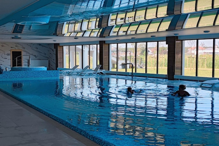 Apartment complex located directly on the banks of the Dziwna River. In addition to the apartments, it offers a SPA zone with an indoor pool, whirlpool and sauna. The beach is approx. 700 m away. The resort centre is approx. 250 m away.
The comfortable apartment is located on the ground floor. It consists of a living room combined with a well-equipped kitchen, a bedroom with a wide double bed and a bathroom with a shower (there is a washing machine). The living room has a double sofa bed, a table and TV. The apartment has a large, covered balcony. Central heating. Wireless internet is available.
The complex has a nice, indoor swimming pool (+ children's paddling pool), whirlpool, sauna and fitness room. Parking is available for those arriving by car.
The price of your stay includes: electricity and water consumption, swimming pool, sauna, whirlpool, fitness room, parking space in the underground garage, internet. A cot and a high chair are available on request.
DziwnÃ³w has a clean, sandy and guarded beach, separated from the city by a strip of dunes. In the summer, children can use the water slide and inflatable structures for jumping. Wooden breakwaters protrude from the sea, on which seagulls often sit. In the summer, you can also take a ride on a banana or a wheel pulled by a motorboat. An additional, fantastic attraction of the beach is the walking promenade, which stretches along the dunes of the sandy, wide beach. It is an ideal place for walkers. While resting, you can enjoy the beautiful views and the sunset. In the meantime, you can sit on the benches that have been installed along the promenade. In the local fishing port, you can buy fish straight from the cutter. There are also sales stands offering smoked fish and other fish products.