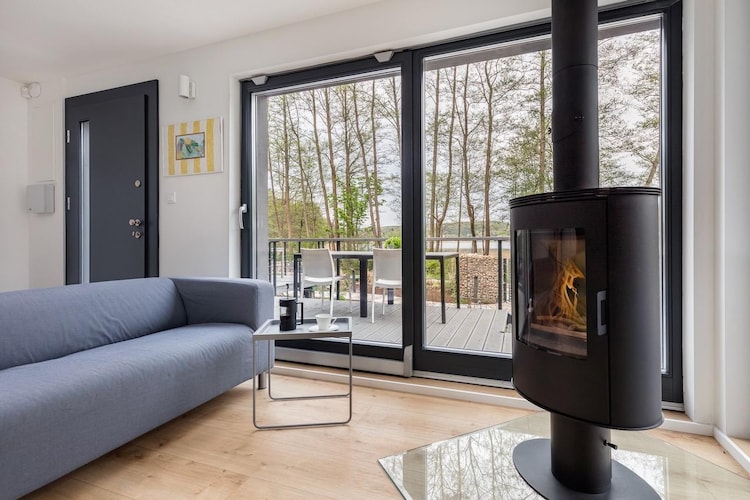 The intimate holiday resort (3 holiday homes) is located in an idyllic area, just 30 m from the shores of Lake Wisełka. You can find peace and quiet here, and in the immediate vicinity you can go for a walk or a trip on foot or by bike.
A comfortable, two-story holiday home in a modern, Scandinavian style, with a large terrace overlooking the lake. A complete set of garden furniture awaits you on the terrace. On the ground floor there is a large living room with a fireplace (wood for an additional fee), satellite TV, 2 sofas and a table with chairs. An open, perfectly equipped kitchen. On the ground floor there is also a double bedroom and a bathroom with a shower. On the first floor there are another 2 bedrooms and a second bathroom with a shower. Electric heating (underfloor heating in the bathrooms). Wireless internet is available. The house is surrounded by a well-kept garden, and in it a free-standing sauna (additional fee). There is also a safe parking lot (2 spaces/house). You can rent a grill on site.
The price of your stay includes: bed linen, electricity consumption (in the period 21.06 - 30.08), water consumption, internet, parking (2 spaces per house). Baby cot and high chair on request. 30 m from the holiday home there is a swimming area on the lake, with a small beach. Just 2.5 km away there is also a beautiful Baltic beach. On the other side of the lake (800 m walk) there is a water equipment rental (SUP, water bike, kayak, sailboat). In the center of the town, approx. 900 m from the holiday home, there are 2 grocery and industrial stores and several restaurants. There is also a bike rental. In the nearby area there is the Wolin National Park, with a bison reserve and many hiking and cycling trails.