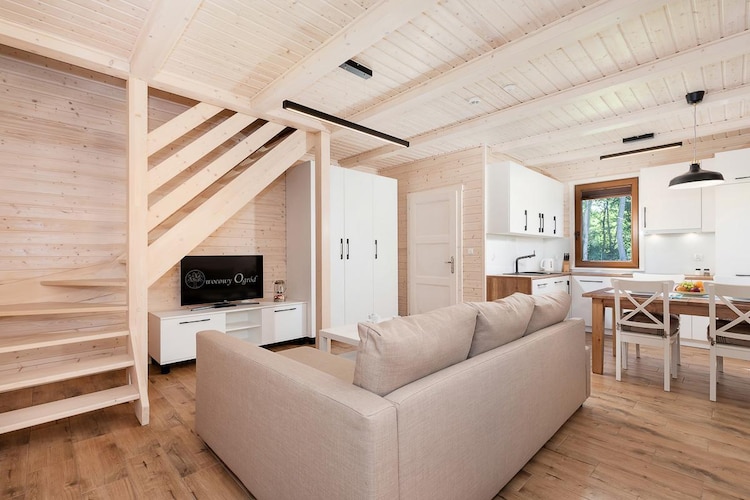 An ideal location, 200 meters from a sandy beach, on the eastern edge of Rewal, essentially between two attractive seaside resorts – Rewal and Niechorze. This holiday resort, set within a fenced area and featuring a summer swimming pool, offers comfortable accommodation in two-story holiday homes.
The holiday home features a covered terrace with garden furniture and barbecue facilities. On the ground floor, there's a spacious living room (TV, dining table, double sofa bed), a well-equipped kitchen, and a bathroom with a shower. On the first floor, there are two bedrooms: one with a double bed and a balcony, and one with two single beds (both can be converted to sleep two people). Air conditioning with cooling and heating functions is provided. High-speed internet is available.
The resort's biggest attraction is the heated summer swimming pool in the garden with a separate children's pool. There's also a children's playground, secure parking, and a washing machine in the outbuilding. For a small fee, we provide equipment for small children: a crib, highchair, and bathtub. The price includes: bed linen, towels, electricity, water, air conditioning, heating, parking (2 spaces per house), internet, and final cleaning.
Rewal is a charming seaside town. It offers a clean beach and a guarded swimming area. There's also a fishing base, perfect for souvenir photos. While near the beach, be sure to see the town's symbol – the mighty Rewal Whales – on the promenade, near the viewing platform. The town boasts a renovated narrow-gauge railway, which offers a charming route to nearby resorts.